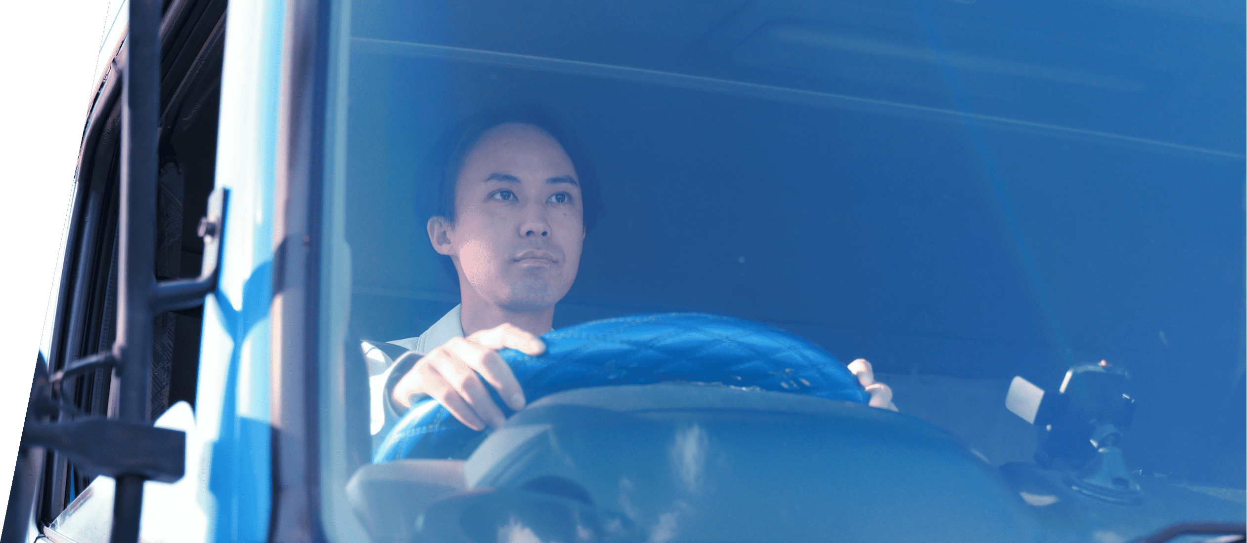 トラックに乗りハンドルを握る男性従業員