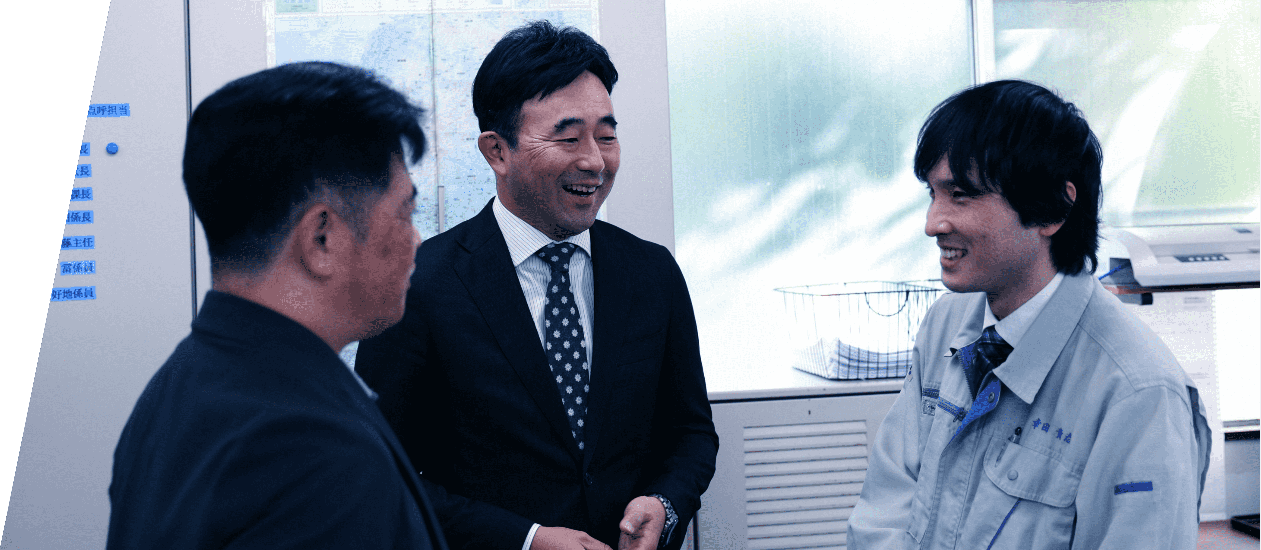 社長と男性従業員2人が談笑する様子